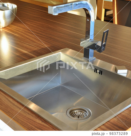 Interior of modern kitchen and stainless steel sink, tap and drain Interior of modern kitchen and stainless steel sink, tap and drain 98373289
