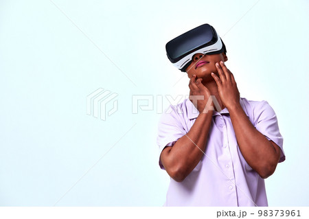 A cheerful girl in virtual reality glasses. Blue and purple colors. A cheerful girl in virtual reality glasses. Blue and purple colors. 98373961