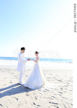 海ロケーションでフォトウエディングの新郎新婦、海背景にてロマンチックな指輪の交換シーン 海ロケーションでフォトウエディングの新郎新婦、海背景にてロマンチックな指輪の交換シーン 98374469