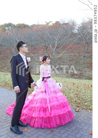 グラデーションピンクのカラードレス姿が可愛い新婦様とタキシード姿の新郎様のフォトウエディング 98374952