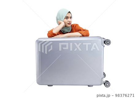 Asian Muslim woman in a headscarf sitting with a suitcase 98376271