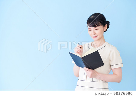 手帳を書くエステ・美容クリニックの女性 98376996