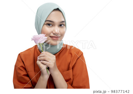 Asian Muslim woman in a headscarf holding a rose flower 98377142