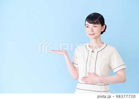 手で案内するエステ・美容クリニックの女性 98377720