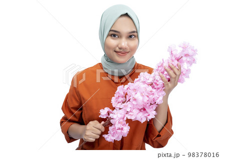Asian Muslim woman in a headscarf holding a pink flower 98378016