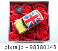 黄色いミニカーと赤いバラの造花 98380143