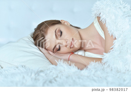 young woman lying on soft bed in the bedroom 98382017
