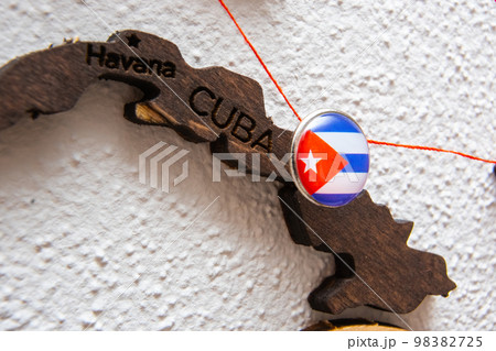 Cuba flag on the pushpin with red thread showed the paths of movement or areas of influence in the global economy on the wooden map. Planning of traveling or logistic concept. Network connection.  98382725