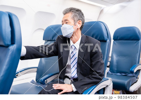 マスクをして飛行機に乗る乗客 98384507
