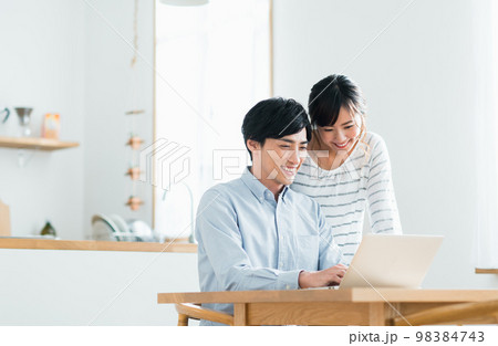 パソコンを見る若い夫婦 98384743