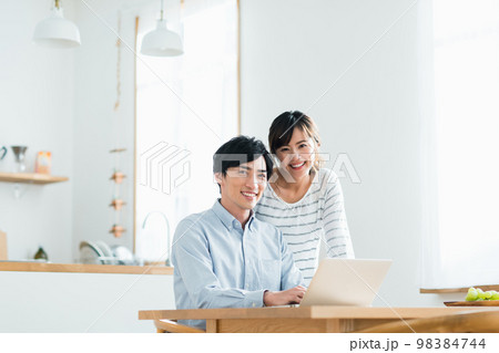 パソコンを見る若い夫婦 98384744