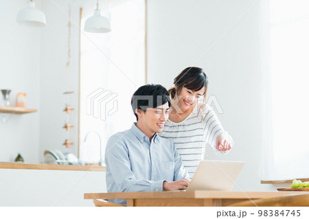 パソコンを見る若い夫婦 98384745