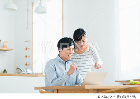 パソコンを見る若い夫婦 98384746