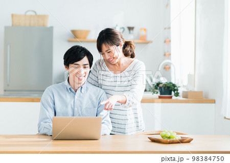パソコンを見る若い夫婦 パソコンを見る若い夫婦 98384750