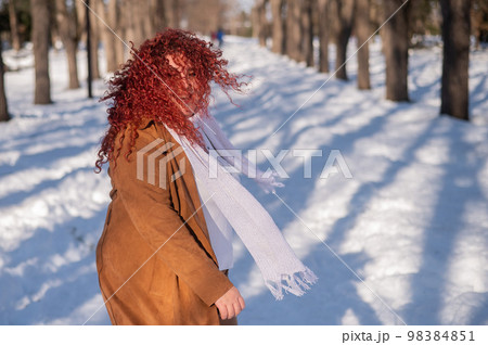 Portrait of an excited red-haired curly fat woman in the park in winter. Portrait of an excited red-haired curly fat woman in the park in winter. 98384851
