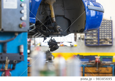 Car service center concept, vehicle raised on lift at maintenance station, auomobile repair, check up, repairing the car Car service center concept, vehicle raised on lift at maintenance station, auomobile repair, check up, repairing the car 98385695