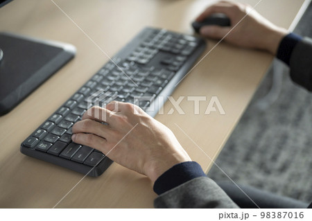 PCのキーボードで入力をする30代の男性の手元 PCのキーボードで入力をする30代の男性の手元 98387016