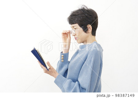 読書する老眼の中年女性　白背景 98387149