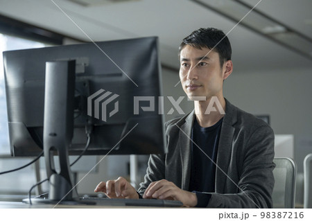 デスクトップパソコンで作業をする30代の男性 98387216