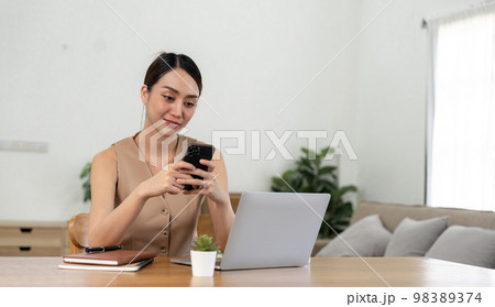 asian woman using mobile phone during checking an email or social media on internet. accounting financial concept 98389374