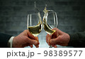 Two men clinking with glasses of white wine, celebrating success. 98389577