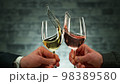 Two men clinking with glasses of wine, celebrating success. 98389580
