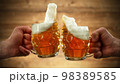 Two glasses of beer in cheers gesture, splashing. 98389585