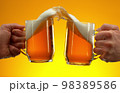 Two glasses of beer in cheers gesture, splashing. 98389586