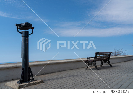 Coin-operated binoculars with sea view on the waterfront. The blue sea with the horizon. 98389827