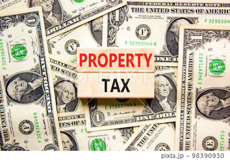 Property tax symbol. Concept words Property tax on wooden blocks. Beautiful background from dollar bills. Business and property tax concept. Copy space. 98390930
