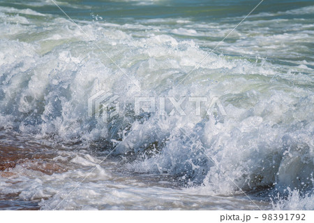 Splashes of water and foam against the sea on a sunny summer day 98391792