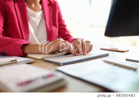 Business woman is typing on computer keyboard while sitting in her office. Business woman is typing on computer keyboard while sitting in her office. 98393485