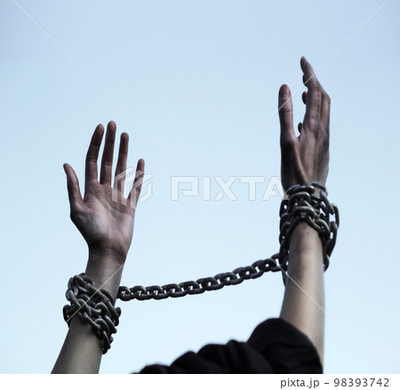 Praying man with shackled hands Praying man with shackled hands 98393742