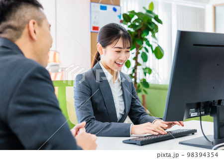 パソコンを見ながら打ち合わせをするビジネスパーソン 98394354