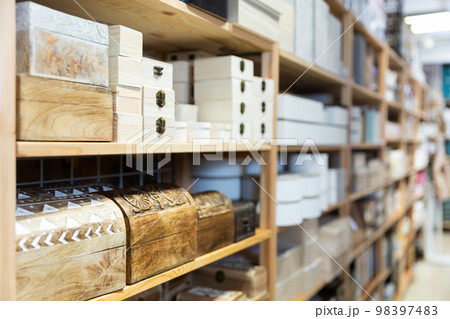 Supermarket of household goods - wooden original caskets on shelves Supermarket of household goods - wooden original caskets on shelves 98397483