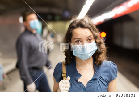 Woman in medical mask waiting for subway train Woman in medical mask waiting for subway train 98398101
