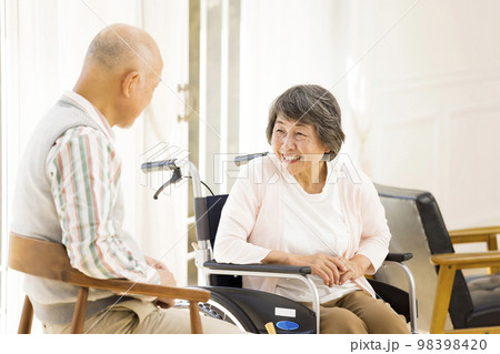 介護老人施設で会話をするシニア男女 98398420