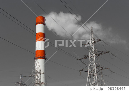 The pipe of the industrial plant emits toxic grey smoke into the atmosphere sky and air. Pollution of the environment and ecology. Thermal power plant power lines high voltage 98398445