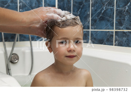 Mom's hands washing little girly's head in the bathroom. The symbol of purity and hygiene education. 98398732