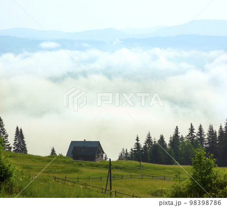 Lonely shepherds house in mountains with clouds below Lonely shepherds house in mountains with clouds below 98398786