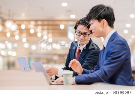 後輩にアドバイスするビジネスマン 98399097