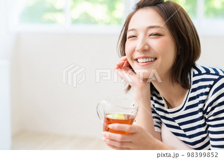 部屋でリラックスする若い女性 飲み物 部屋でリラックスする若い女性 飲み物 98399852
