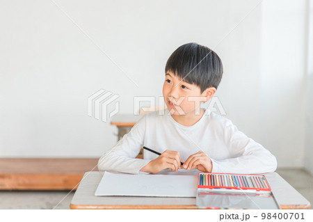 学校の図工の授業・お絵かき教室・習い事で色鉛筆を使って絵を描く小学生の男の子 98400701