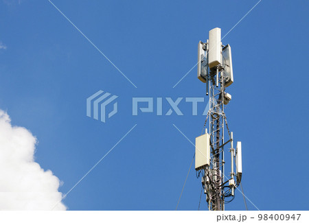 Communication antenna tower with blue sky,Telecoms technology. Mobile phone base station Communication antenna tower with blue sky,Telecoms technology. Mobile phone base station 98400947
