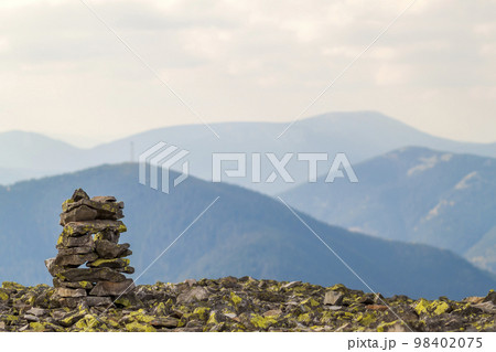 Cairns or rock piles on the top of mountain overlooking the highlands. Pyramid of stones. Stone tower. Pile of rocks stone in mountains. 98402075