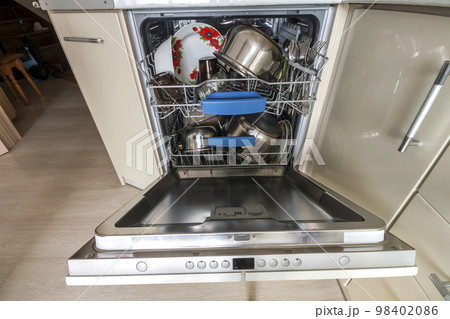Build-in dishwasher with opened door with clean glass and dishes in modern kitchen, selective focus Build-in dishwasher with opened door with clean glass and dishes in modern kitchen, selective focus 98402086