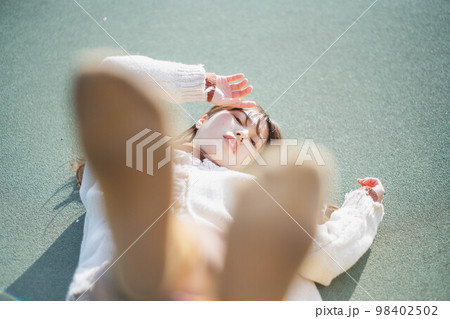 海辺でポージングをとるアンニュウイな雰囲気な女性 98402502