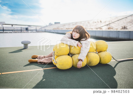 海辺でポージングをとるアンニュウイな雰囲気な女性 98402503