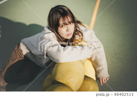 海辺でポージングをとるアンニュウイな雰囲気な女性 98402513