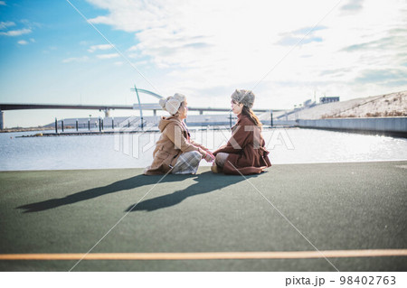 海の見える港で楽しそうに雑談する女性達 98402763